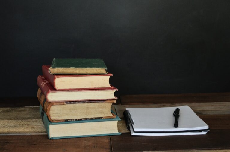 Stack of books on a desk, dark background