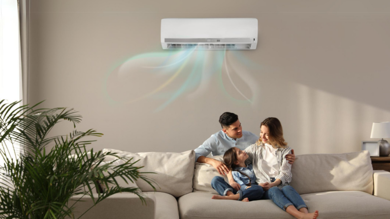 Family sitting comfortably under a single split air conditioner in Melbourne. Front on view, man and women sitting together on couch with child laying across them, artistic blue lines flow from air con unit to illustrate air flow