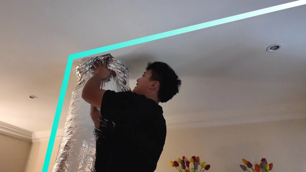 Technician installing ducted air conditioning in a Melbourne home. Professional AC installation with insulated ducting for energy-efficient heating and cooling. Lightning Energy’s in-house tradesmen ensure high-quality workmanship and compliance with Victorian Energy Upgrades rebates.